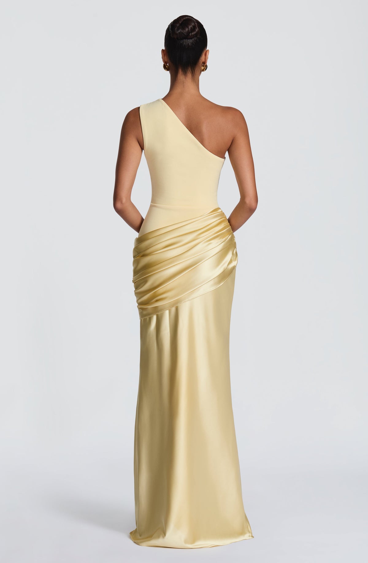 Back view of the pale yellow one-shoulder maxi dress, showing the diagonal strap, smooth bodice and gathered satin hip drape. 27