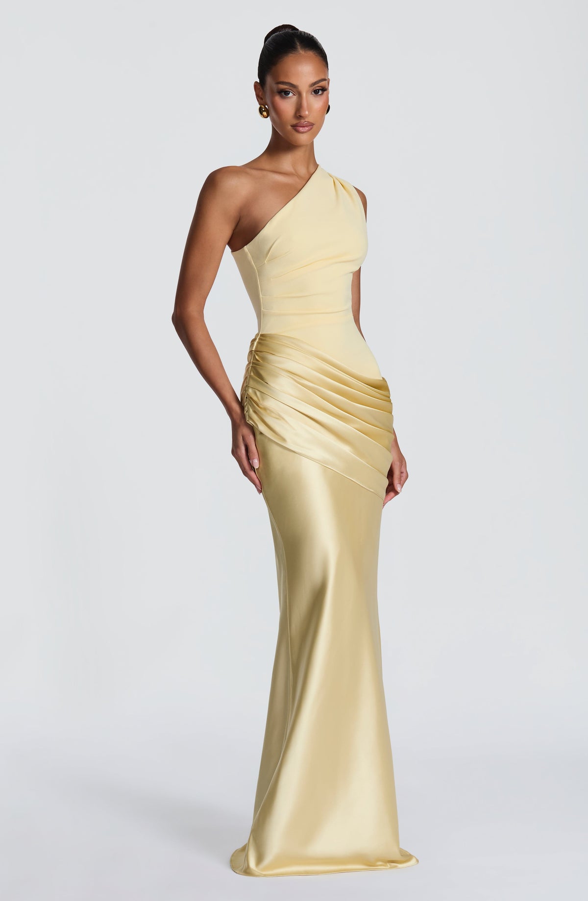 Angled view of the pale yellow satin maxi dress, showing the pleated bodice, side-gathered drape and fluid floor-length skirt. 28