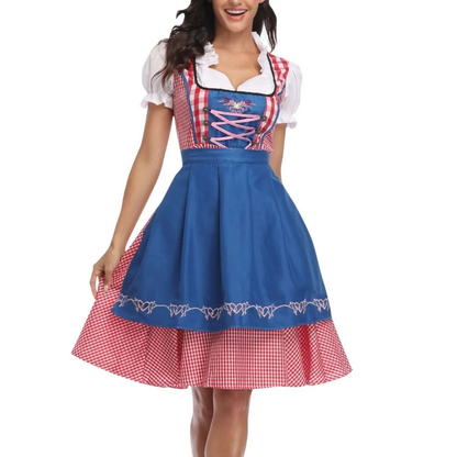 Front view of the red gingham dirndl with a bright blue embroidered apron and pink lace-up bodice, worn by a smiling model. 3