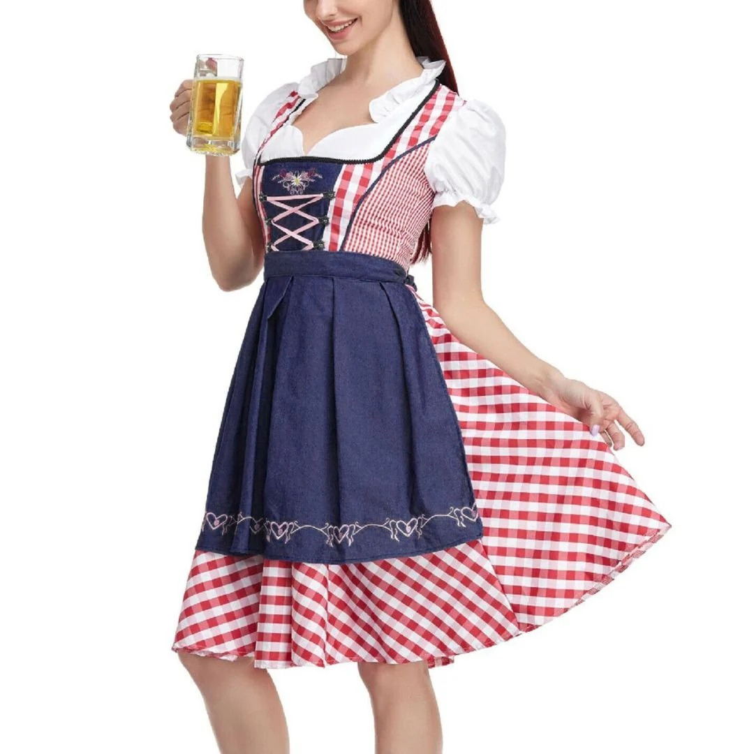 Close-cropped view of the red gingham dirndl with navy denim-look apron, worn by a model holding a glass of beer. 2
