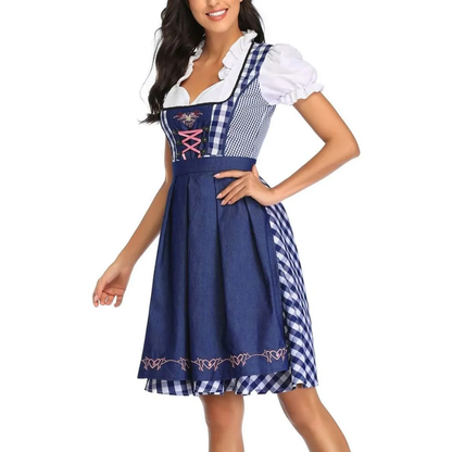 Three-quarter view of the navy and white gingham dirndl with navy apron, pink bodice lacing and a hand on the hip. 6