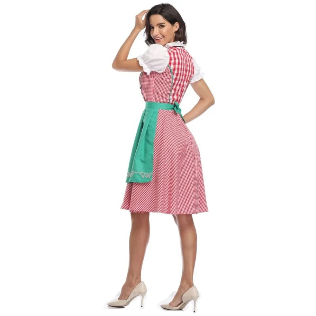 Rear view of the red gingham dirndl with green apron tied in a bow, model looking back with one hand on her head. 10