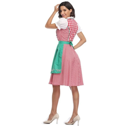 Rear view of the red gingham dirndl with green apron tied in a bow, model looking back with one hand on her head. 10