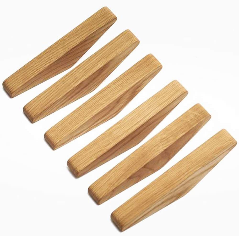 Six light wooden hooks laid out in a diagonal row on a white background, showing their angled shape and visible grain. 1