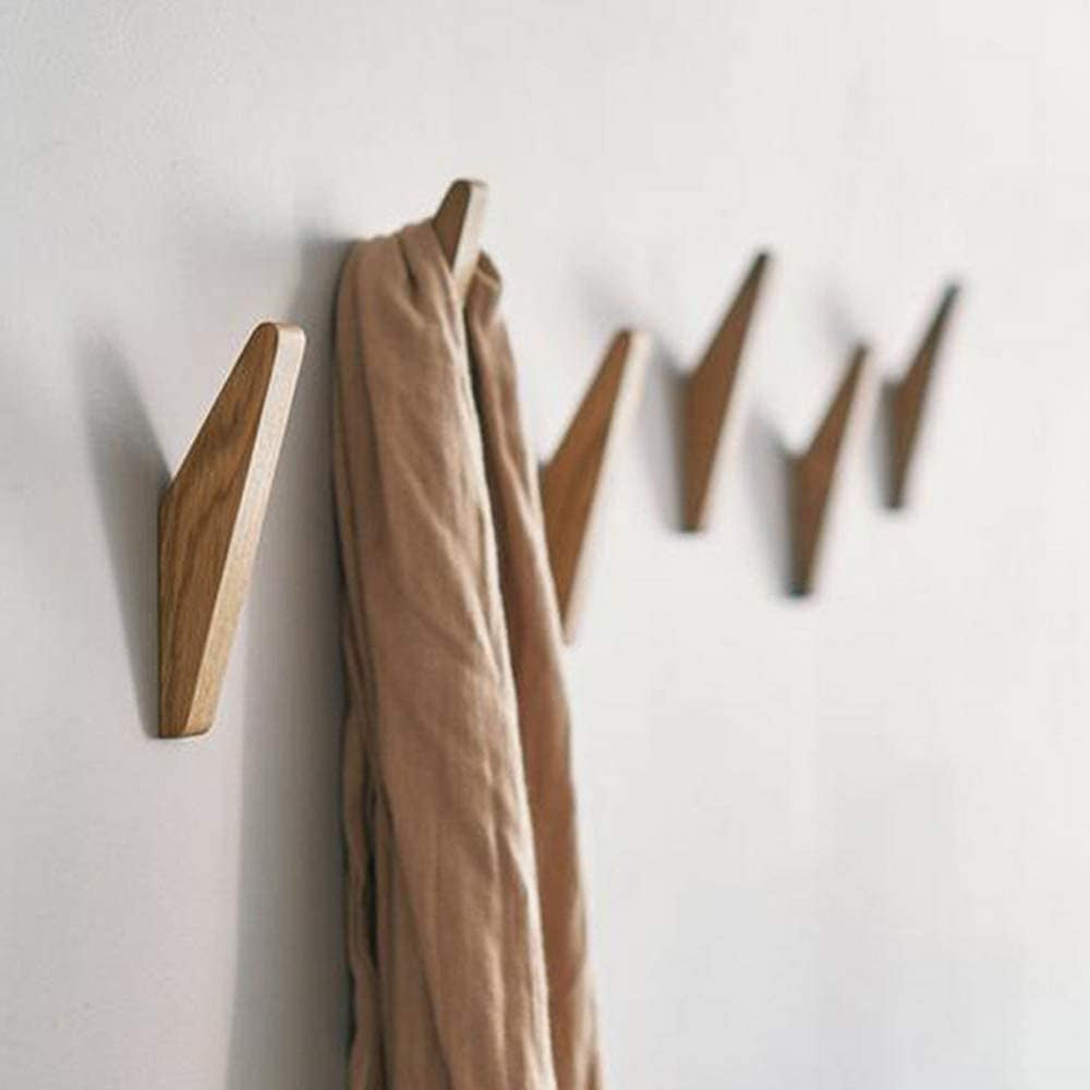 Wooden hooks mounted in a row on a white wall, with a soft beige scarf draped over the first hook. 2