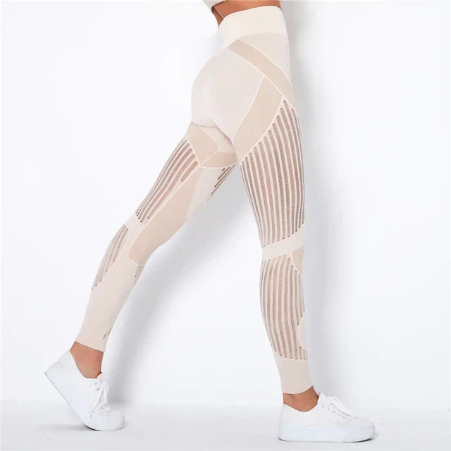 Side view of cream high-waisted leggings with vertical sheer stripe panels, worn with white trainers 1