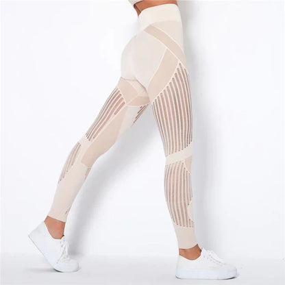 Side view of cream high-waisted leggings with vertical sheer stripe panels, worn with white trainers 1