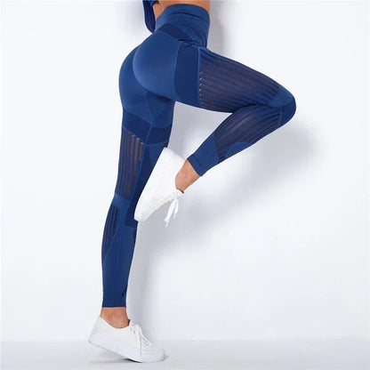 Navy blue leggings worn by a model with one knee raised, showing sheer striped panels along the legs 3