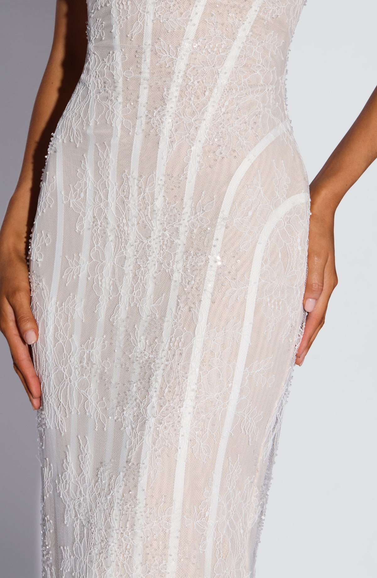 Close-up of the white lace torso and hip, showing the delicate floral lace, beading and sequins and the curved boning. 12
