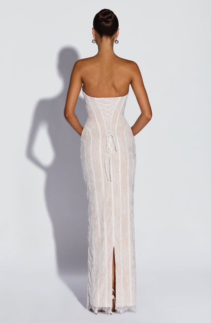 Back view of the white lace dress with corset lacing, trailing ribbon ties and a slit at the hem. 10