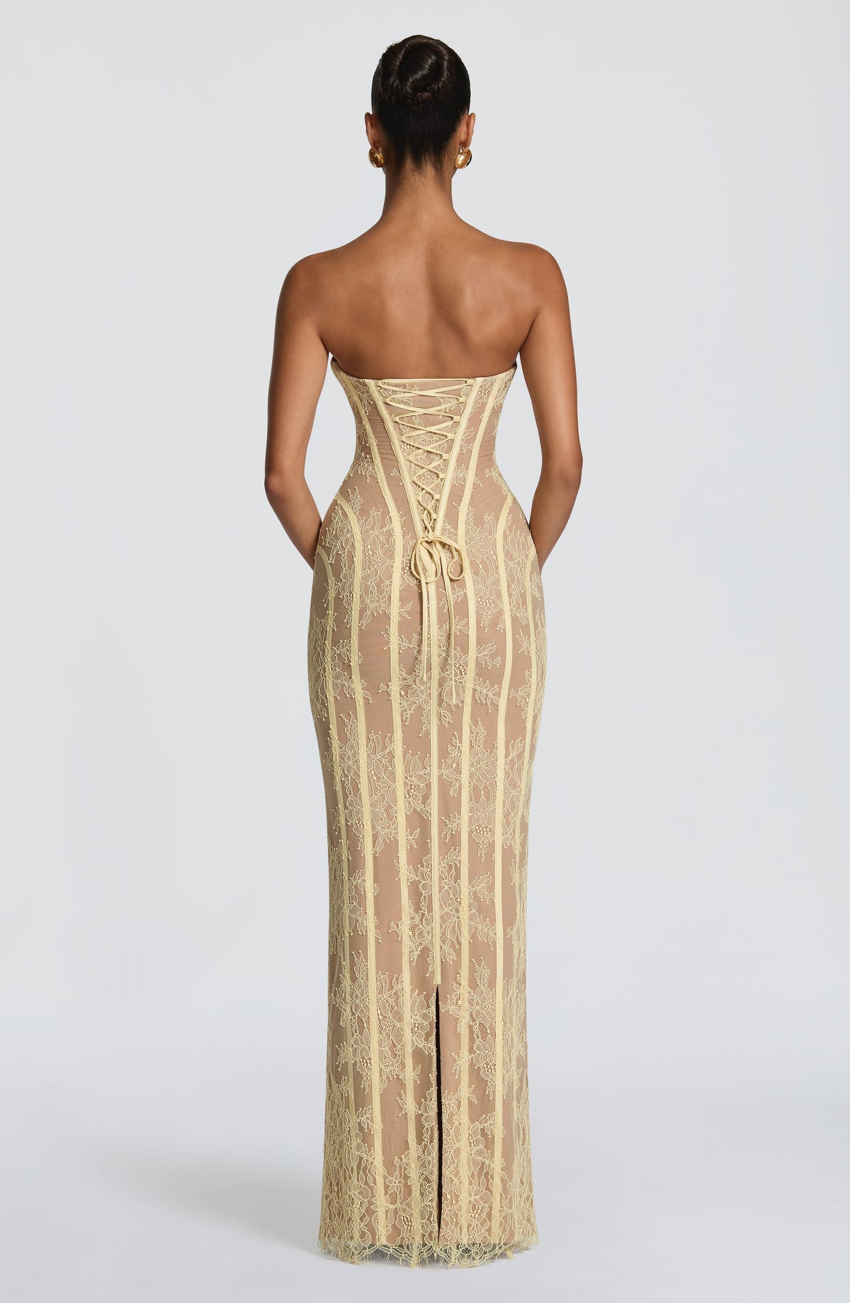 Back view of the pale yellow lace dress, showing the corset lacing, ribbon ties and slit in the skirt. 18