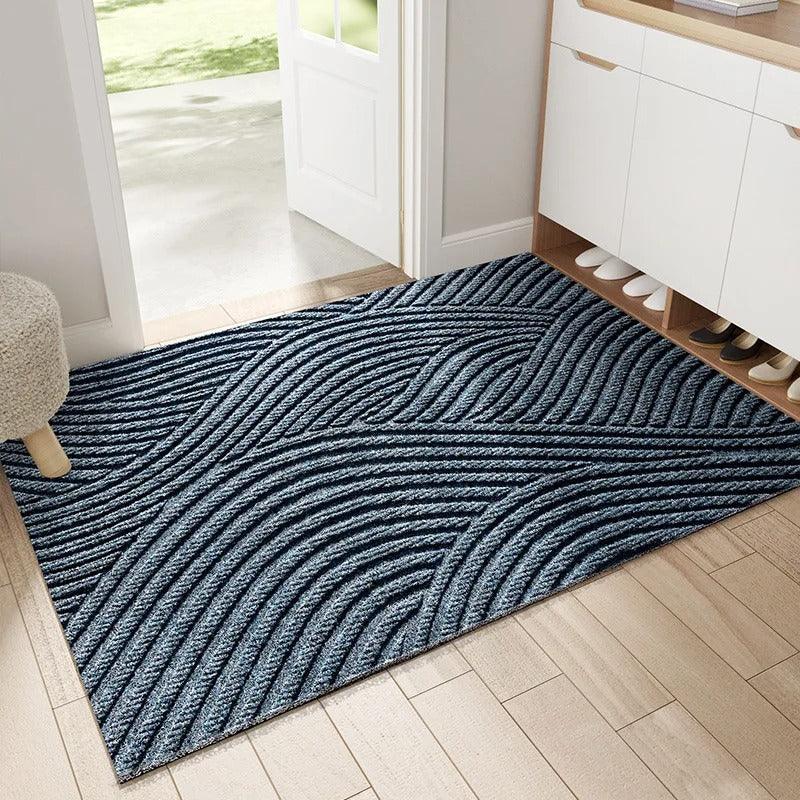 Blue-grey mat with flowing wave-like ridges laid inside a doorway next to a shoe cabinet 4