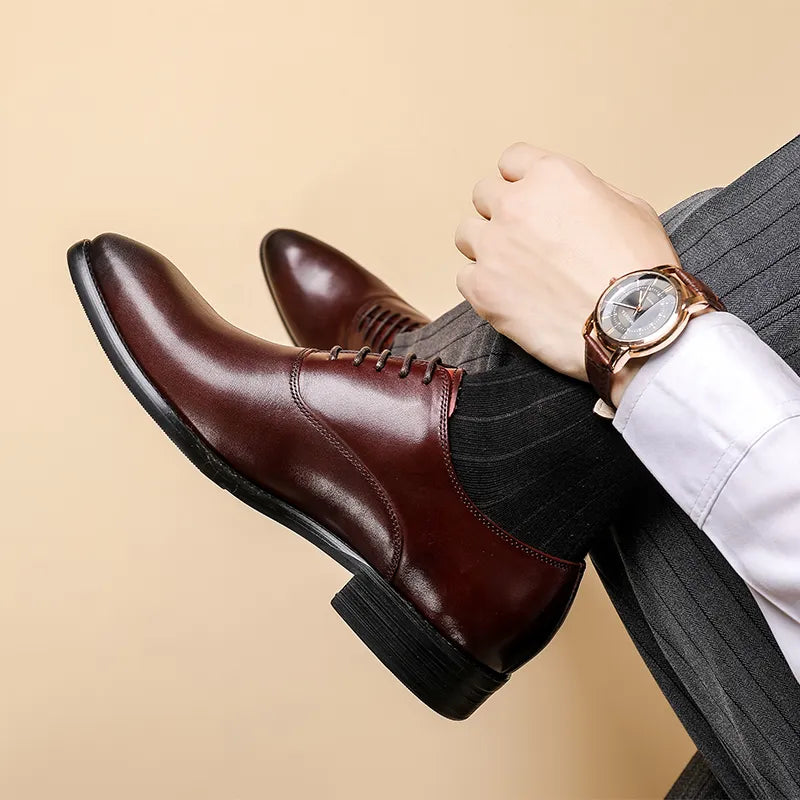 Burgundy leather shoe seen from the side on a crossed leg, worn with dark striped trousers 2