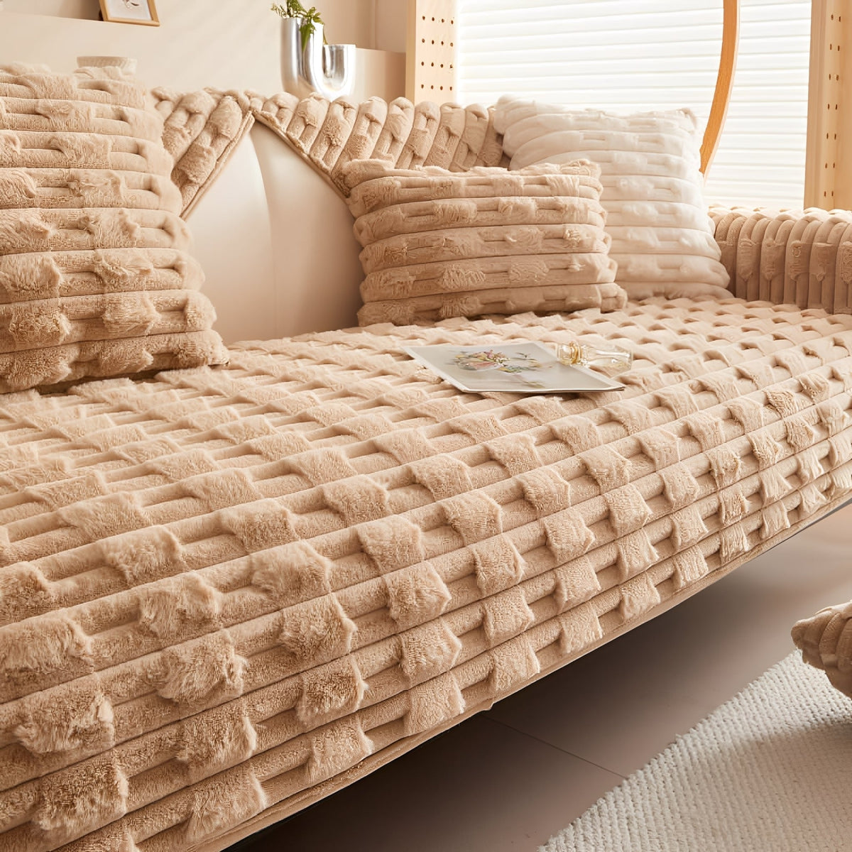 Camel-coloured version of the cover fitted on the sofa, with matching cushions and a cream cushion beside them. 9