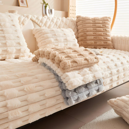 Cream cover on a sofa with folded camel, cream and grey covers stacked on top to show the colour options. 7