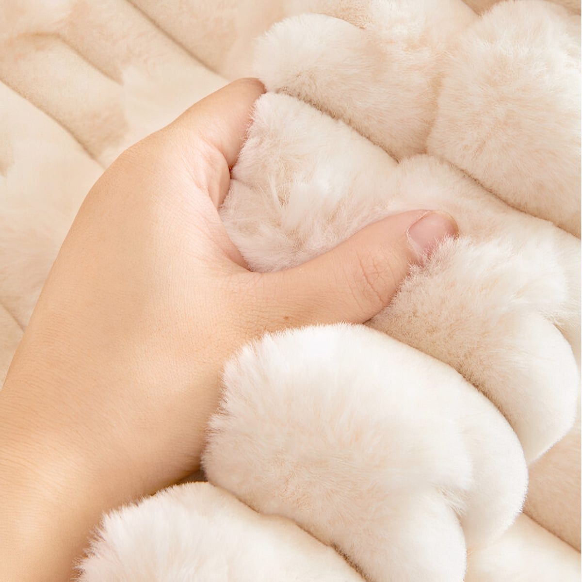 Hand gripping a fold of the cream plush fabric to show how thick, soft and fluffy the pile feels. 4