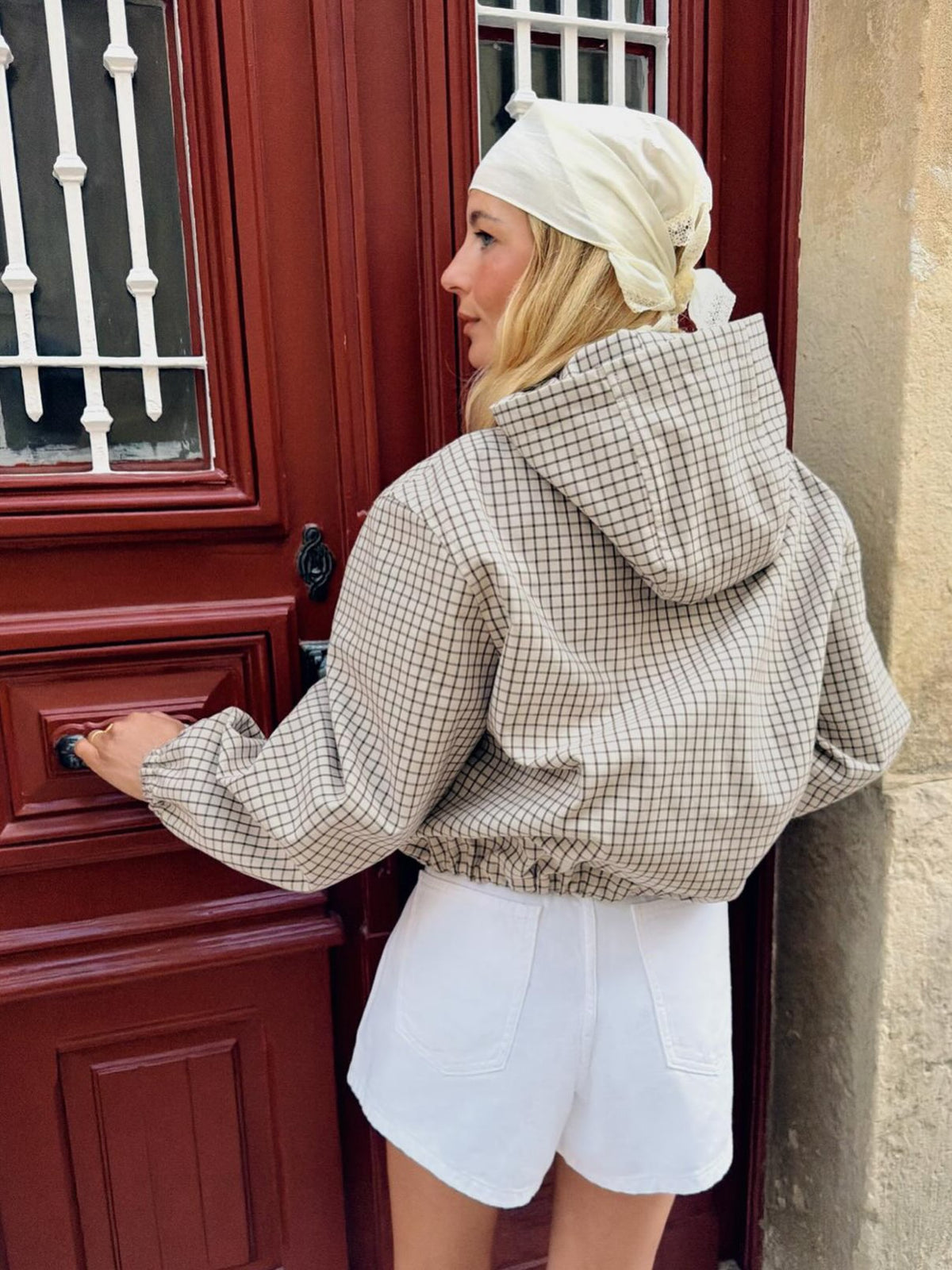 Back view of the checked jacket on a model, showing the hood, elasticated cuffs and gathered hem. 4
