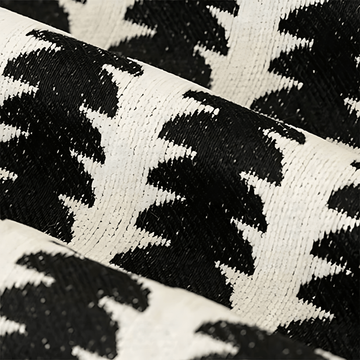 Close-up of the woven chenille fabric in black and cream, showing the dense texture and the leaf-like pattern up close. 2