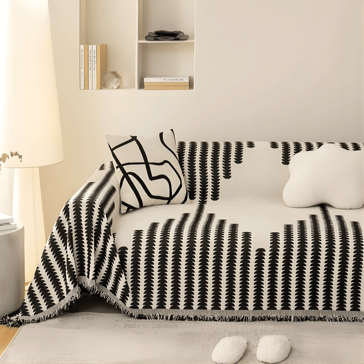 Black and cream patterned cover on a sofa in a bright, warm-toned living room, with a line-art cushion and a cloud-shaped cushion. 3
