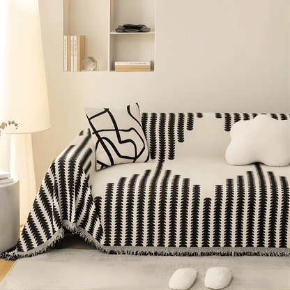 Black and cream patterned cover on a sofa in a bright, warm-toned living room, with a line-art cushion and a cloud-shaped cushion. 3