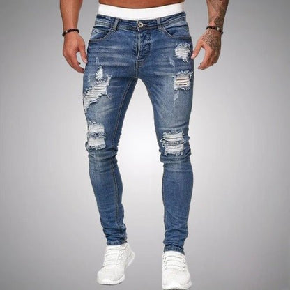 Front view of slim-fit ripped jeans in a mid blue wash, worn with white trainers, showing frayed rips on thighs and knees. 3