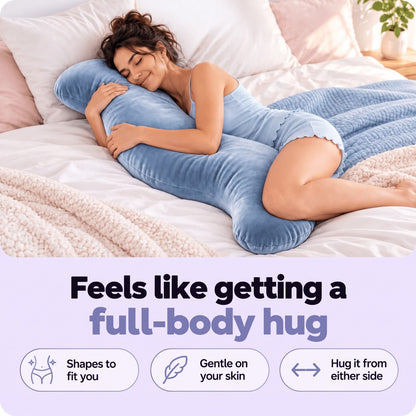 Woman asleep on her side on a bed, hugging the blue S-shaped pillow between her knees 2