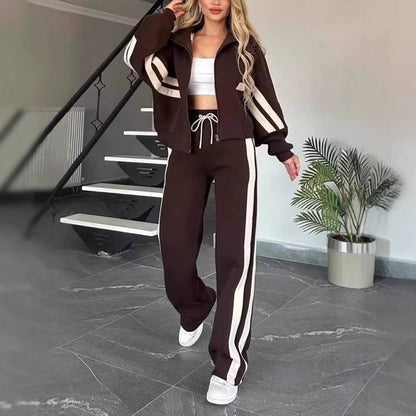 Model walking in the dark brown set with cream stripes, zip jacket worn open and wide-leg drawstring trousers. 8