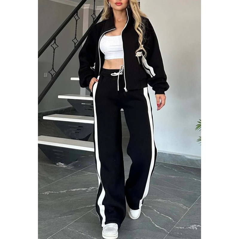 Model in the black and white striped set, jacket open over a white crop top, with a hand in the trouser pocket. 4