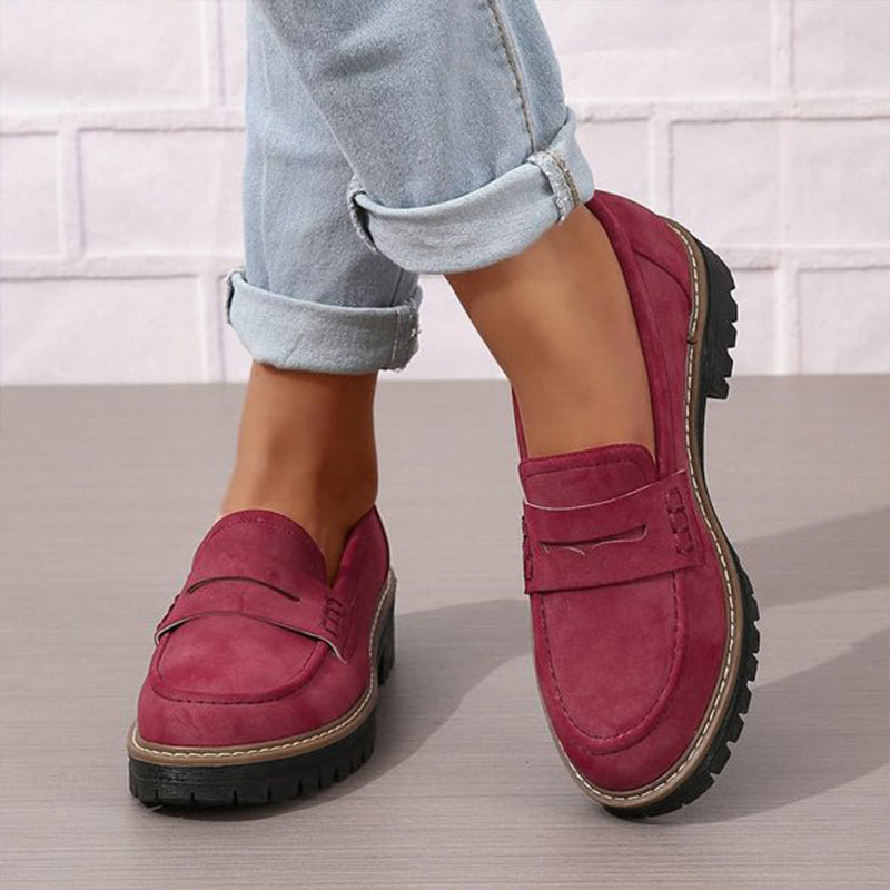 Burgundy suede-effect loafers worn with light blue rolled jeans, viewed from the front and side on a grey floor. 4