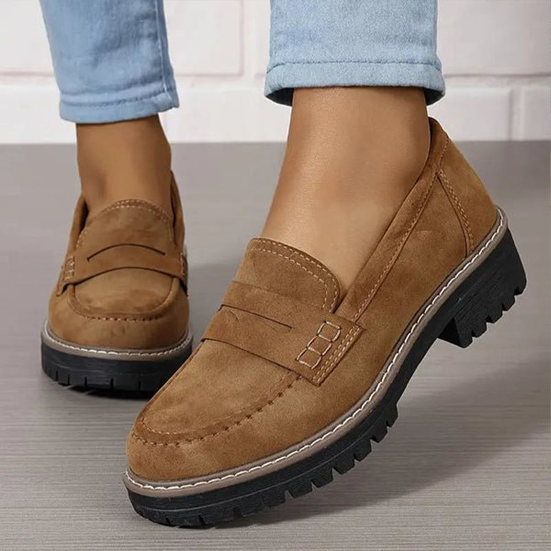 Tan brown loafers with contrast stitching and a chunky black platform sole, worn with light blue jeans. 5