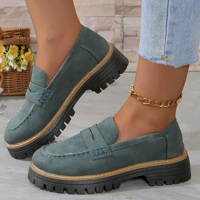 Teal-green suede-effect loafers with tan welt and chunky black sole, worn with a gold ankle chain and frayed jeans. 15