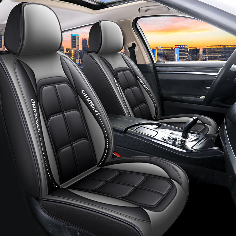 Front seat covers in black and grey with white stitching, fitted to both front seats with a city sunset through the window. 11