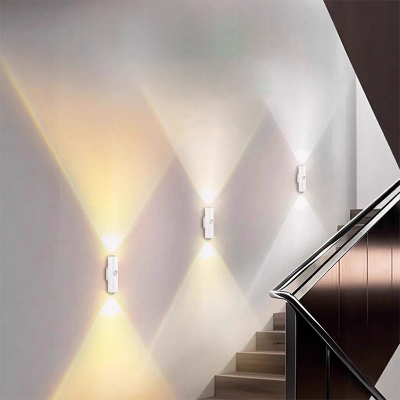 Three white wall lights glowing warm and soft white beams along a staircase wall 8