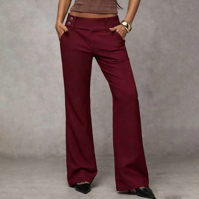 Model wearing burgundy wide-leg trousers with two buttons at the waistband, hands in pockets, front view with black heels. 6