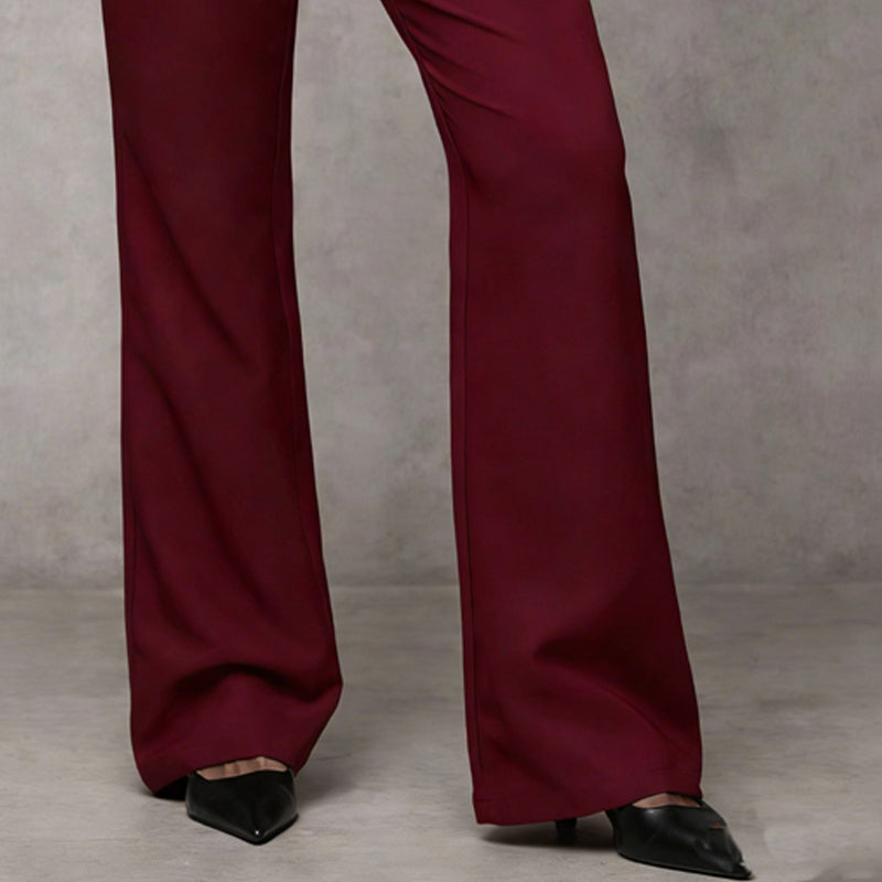 Lower legs of burgundy wide-leg trousers, showing the flared hem falling over black pointed heels. 10
