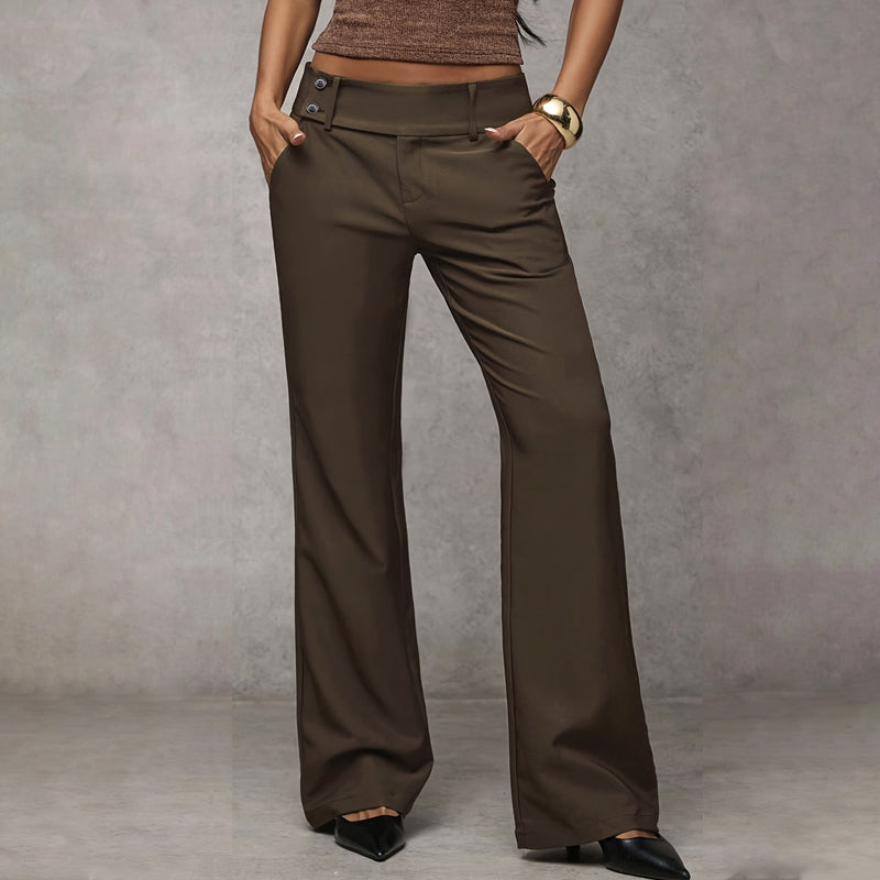 Model wearing olive-brown wide-leg trousers with button tabs at the waist, hands in pockets, with black pointed heels. 3