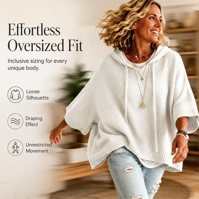 Laughing woman in motion wearing a white oversized hooded knit with ripped jeans, showing its loose, draping fit. 4