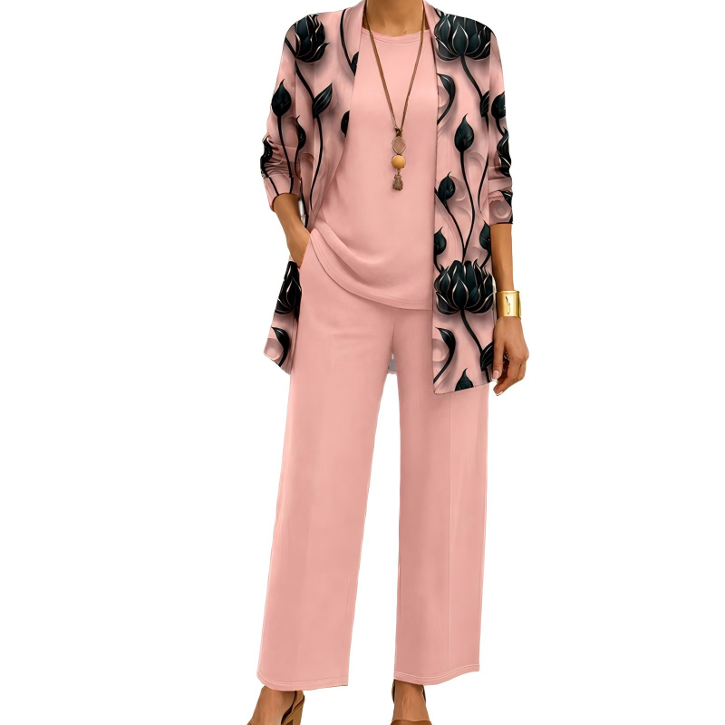 Model wearing the pink set with a black lotus-print open cardigan, matching plain top and wide-leg trousers, styled with a long pendant necklace. 2