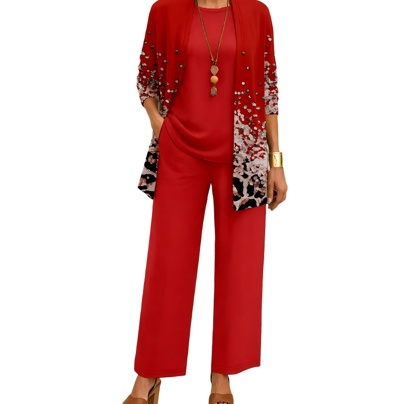 Model wearing the red set, the cardigan fading into a white and black speckled print with small studs, over a plain top and wide-leg trousers. 5