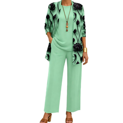 Model wearing the mint green set with a dark lotus-print open cardigan, matching plain top and wide-leg trousers, with a pendant necklace. 6