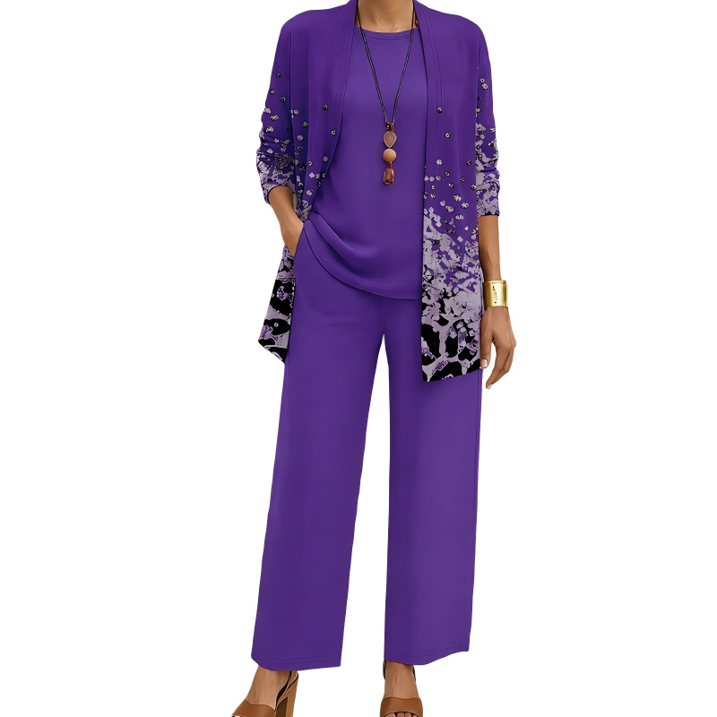 Model wearing the purple set, the cardigan with studs and a lilac and black speckled print near the hem, over a plain top and trousers. 7