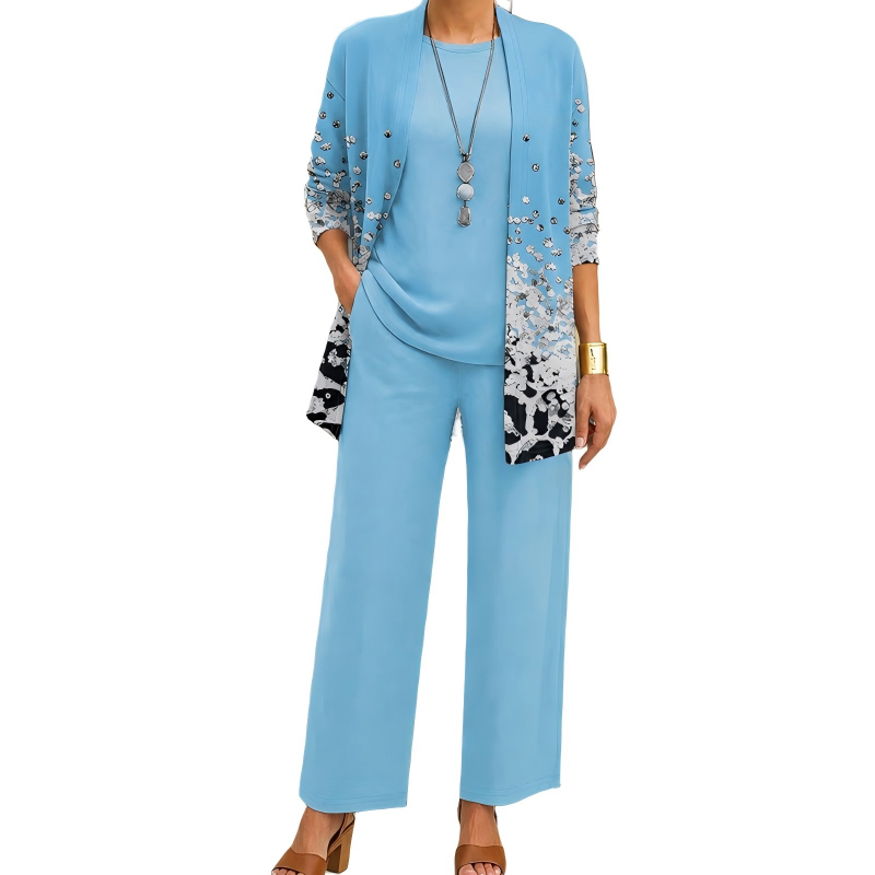 Model wearing the light blue set, the cardigan with silvery studs and a grey and black speckled print towards the hem, over plain top and trousers. 11