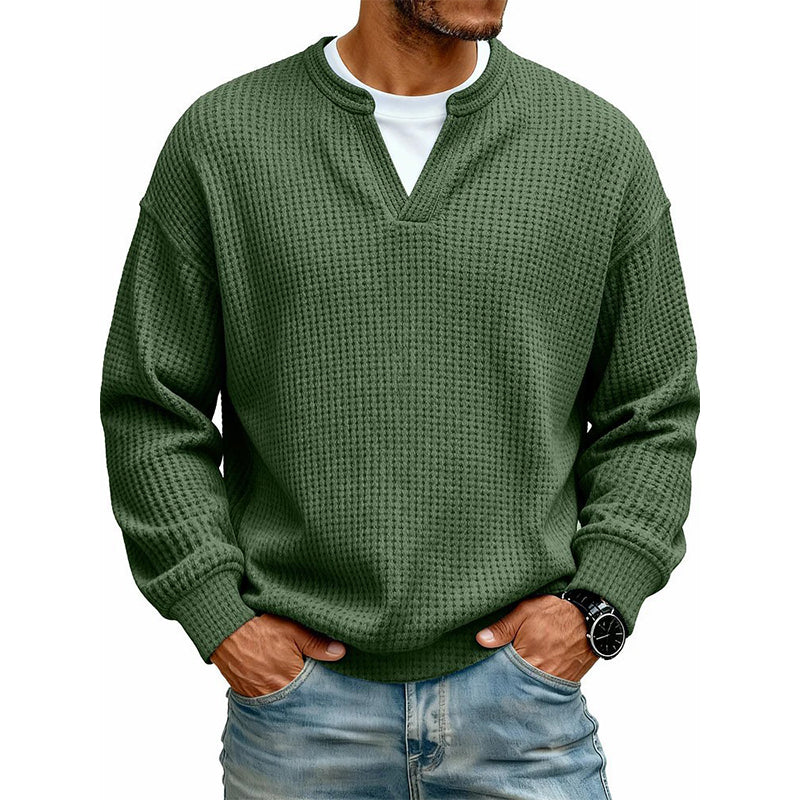 Front view of the waffle knit V-neck top in olive green, worn over a white tee with light jeans. 18