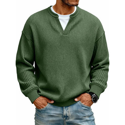 Front view of the waffle knit V-neck top in olive green, worn over a white tee with light jeans. 18