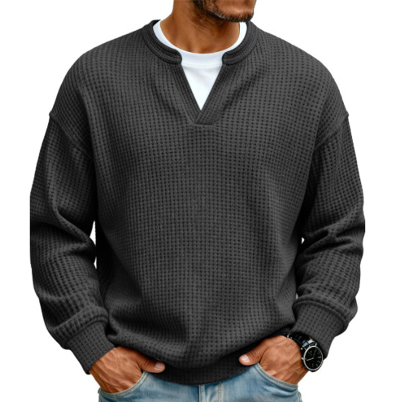 Front view of the waffle knit V-neck top in charcoal black, worn over a white tee with light jeans. 15