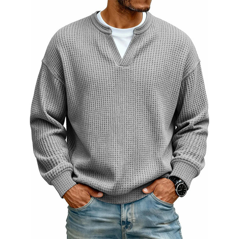 Front view of the waffle knit V-neck top in light grey, worn over a white tee with light jeans. 17