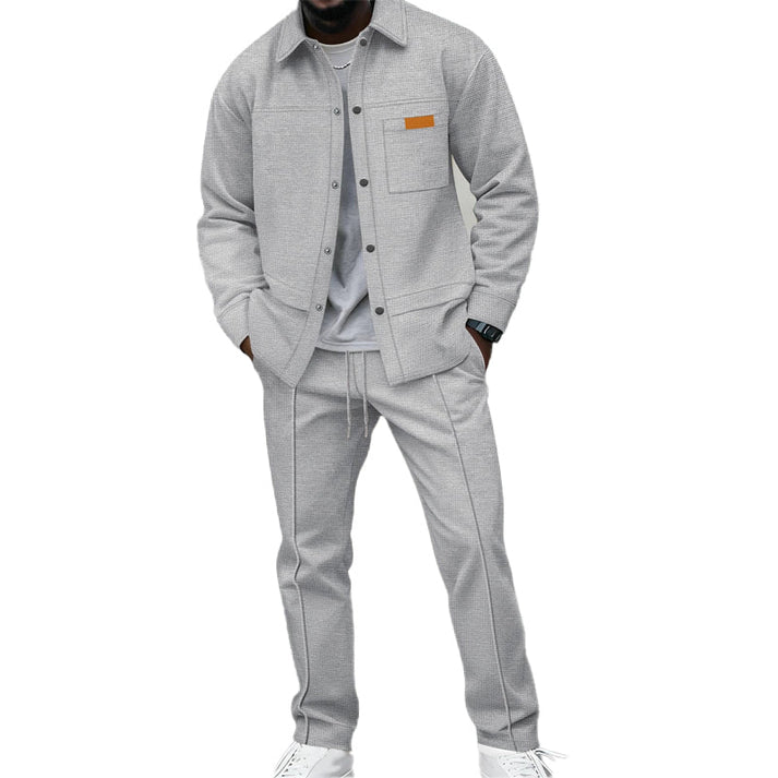 Model wearing the set in light grey, shirt worn open-buttoned over a grey tee with white trainers 2