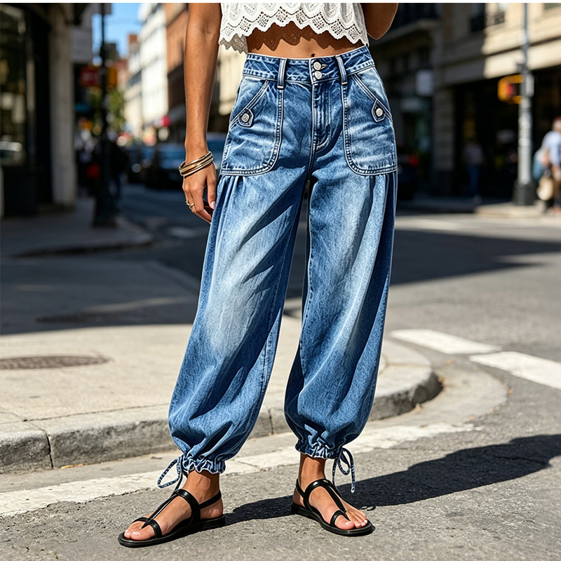 Front view of the blue washed jeans worn on a sunny city street with a lace crop top and black sandals. 2