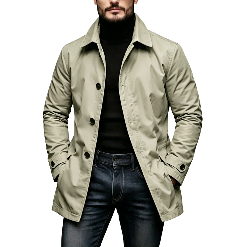 Model wearing the single-breasted trench coat in pale khaki green with a black roll-neck and dark jeans, hands in pockets. 3