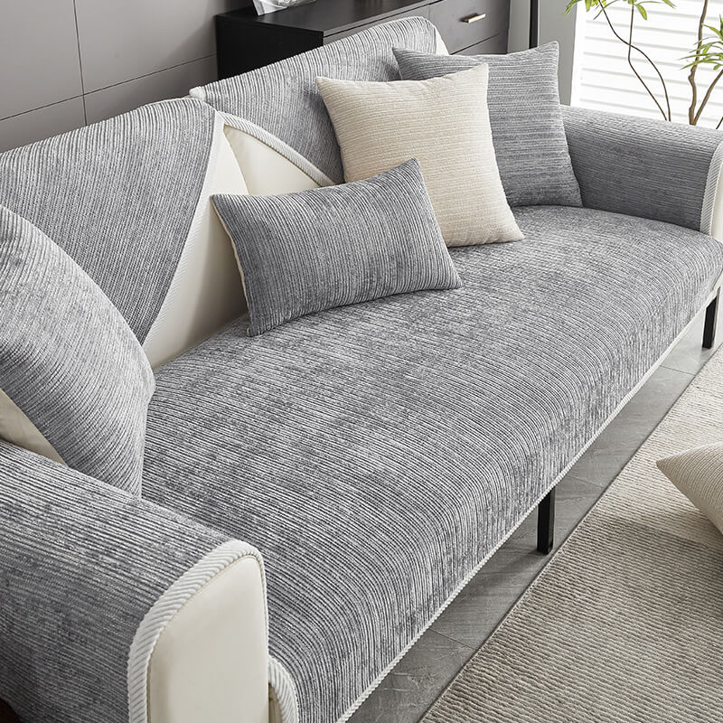 Grey ribbed chenille cover on a cream sofa, styled with grey and cream cushions beside a plant. 1